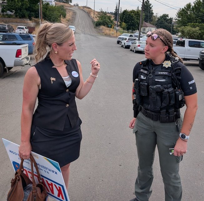 Kaylee Peterson, candidate for US House of Representative, speaks with a police officer during the 2026 Idaho County Fair.